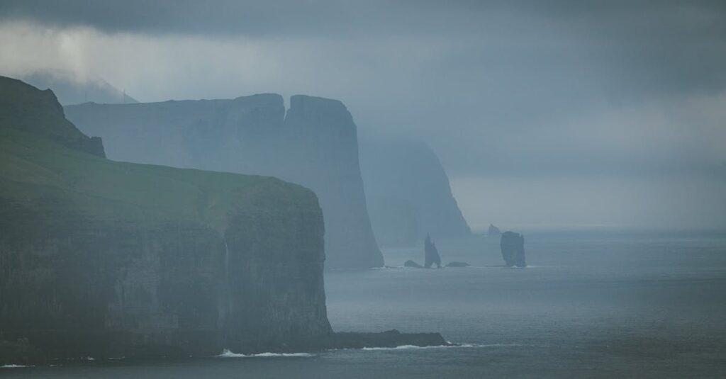 Foggy sea cliffs and green hills in the Faroe Islands overlooking the ocean